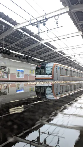雨の日の駅、映る鉄道と空