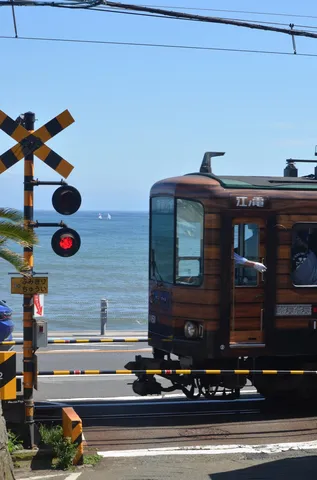 海辺の踏切、レトロ列車と青い空