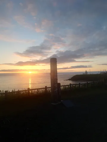 最果てから見守る灯台と夕日