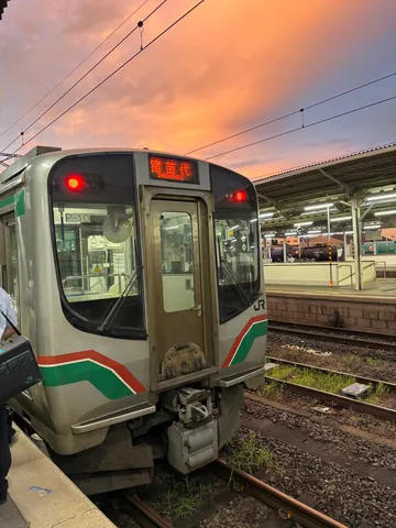 夕暮れの駅と走る列車