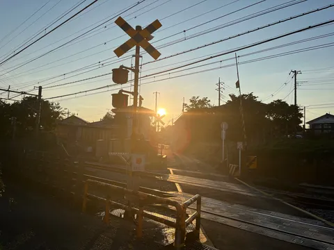夕暮れの踏切、光の道