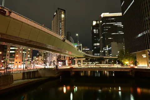 夜の水辺に浮かぶ光の帯