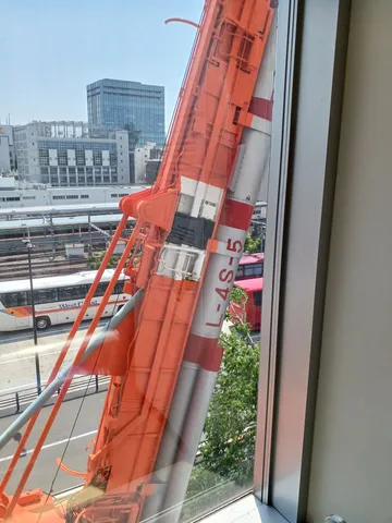 窓越しの巨大クレーンと街並み