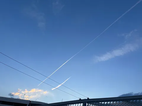 飛行機雲が交差する青空