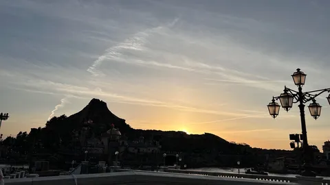 夕暮れの火山と灯りのファンタジー