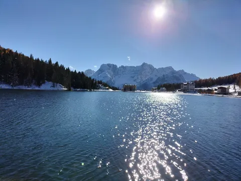 湖面に映る太陽と雪山リゾート