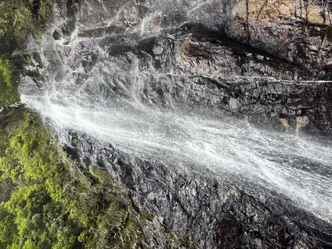 水しぶきが舞う岩肌の滝