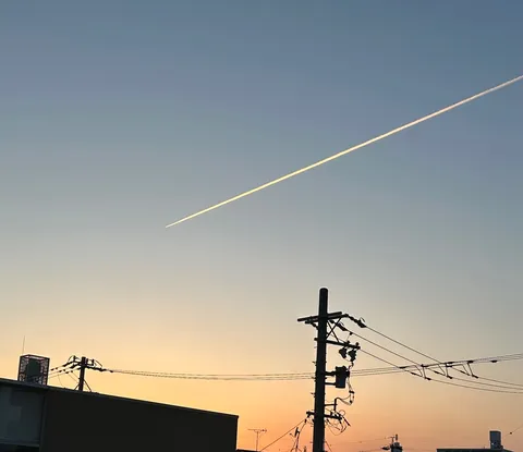 夕焼け空を駆ける飛行機雲