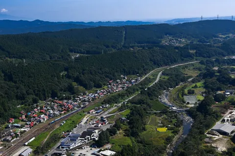 緑深き山間の集落と静かな鉄道