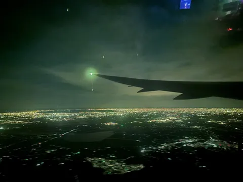 眼下に広がる夜景と飛行機雲