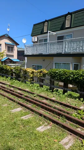 線路が導く、緑のフェンスと家路