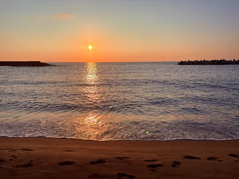 水平線に沈む夕日と波打ち際