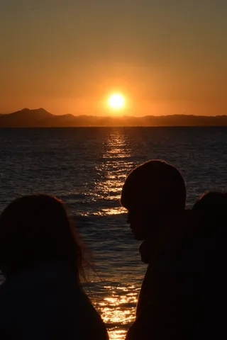 夕焼けの海、二つの静かなシルエット