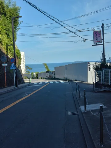 海へと続く坂道、空と舗装のコントラスト
