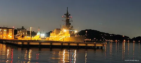 夜港に灯る軍艦のシルエット