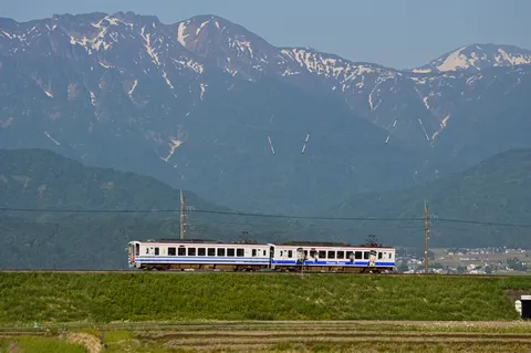 雪山を背景に走る列車、夏。