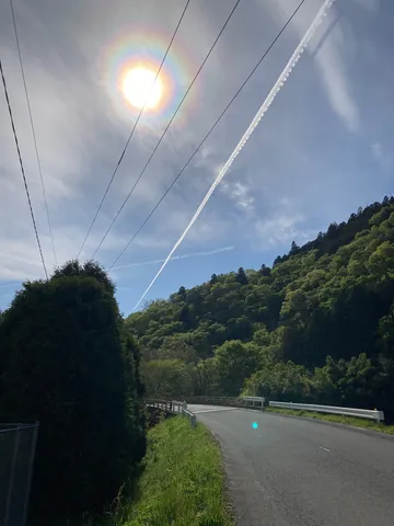 太陽の輪と山里の風景