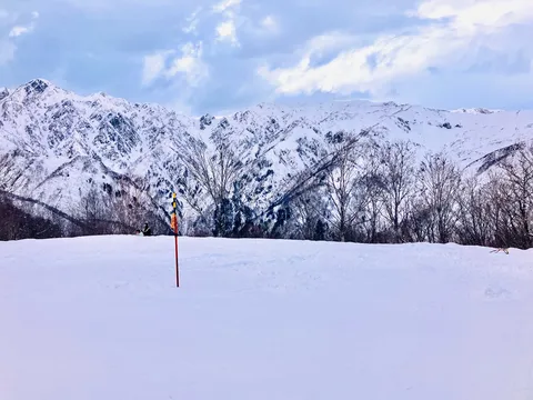 雪山と冬空、鮮やかなポール