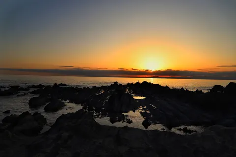 岩場の夕暮れ、静寂の海