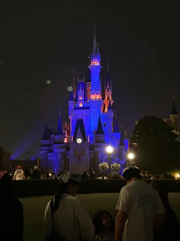 魔法の夜、輝くお城と人々のシルエット