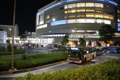 夜のバスターミナル、都会の灯り