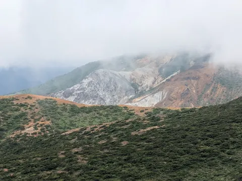 霧と岩肌の静かな山景