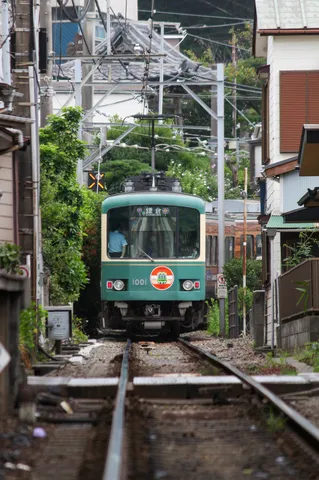 路地を走る緑の電車