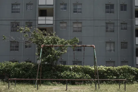 錆びたブランコと集合住宅