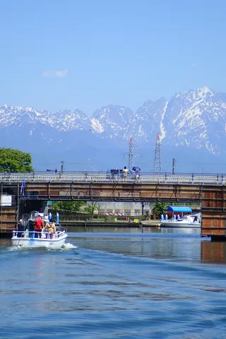 新緑と雪山、水面のコントラスト
