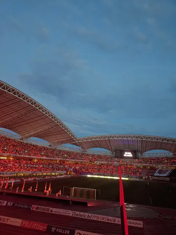 赤い灯りが揺れるスタジアム
