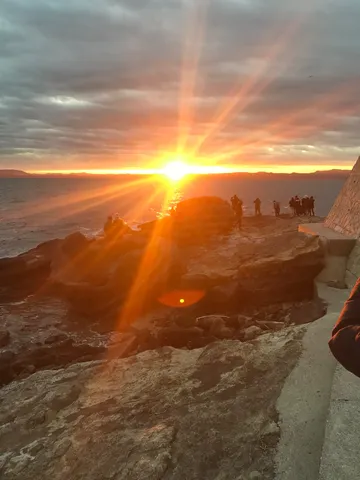 光降り注ぐ夕焼けの海辺