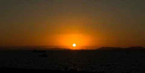 水平線に沈む夕日と静かな海
