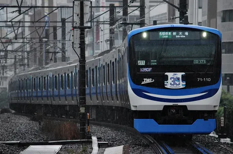 雨降る都会、青い列車
