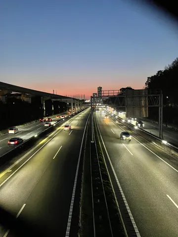 夕暮れの高速に灯る車列