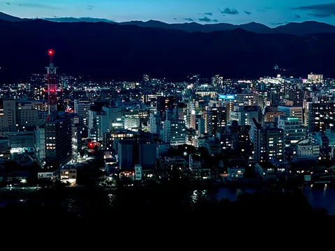 きらめく街と静かな山並み