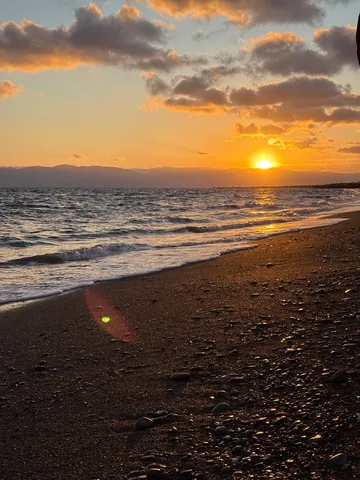 黄金の波打ち際、夕日の煌めき