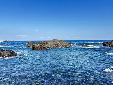 澄み渡る空と岩場の海