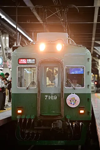 夜のホームを照らす緑の電車