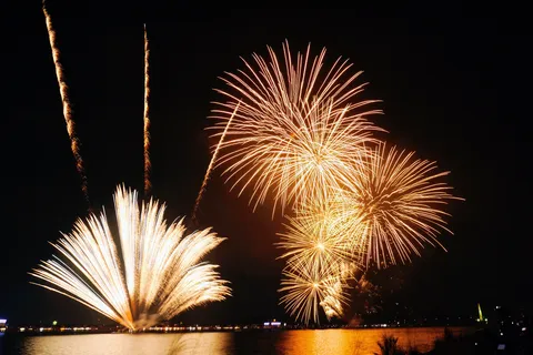 輝く水辺の夜空に咲く大輪の花火