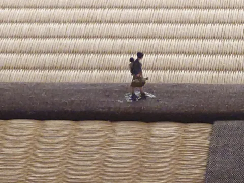 畳の縁を歩く旅人