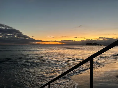 夕陽と波と手すりの影