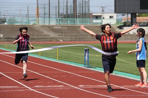 勝利のポーズと背後の激走