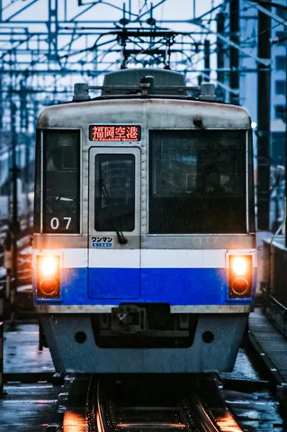 雨のホームに流れる光