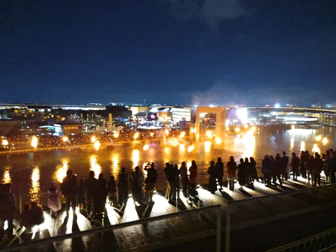 燃え盛る水辺の祭典、夜空に輝く光跡