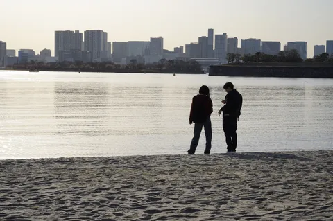 都会の影と静かな浜辺
