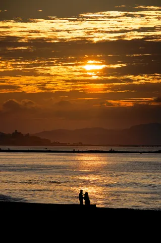 夕陽に染まる海辺の影