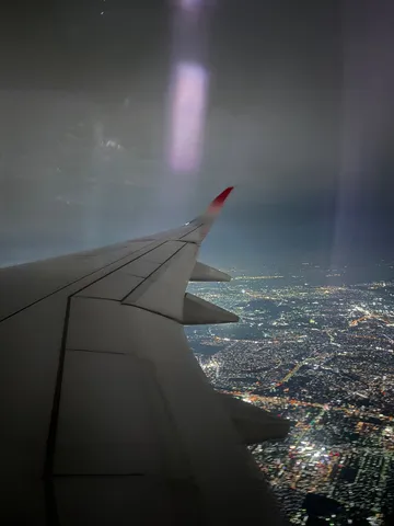 夜景を眼下に、飛行機の翼
