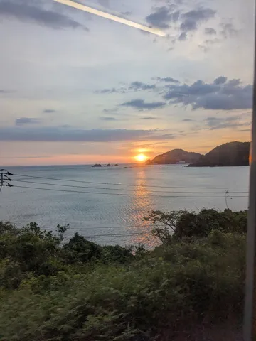 夕陽に染まる海と山のグラデーション