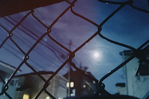 フェンス越しの月夜の情景
