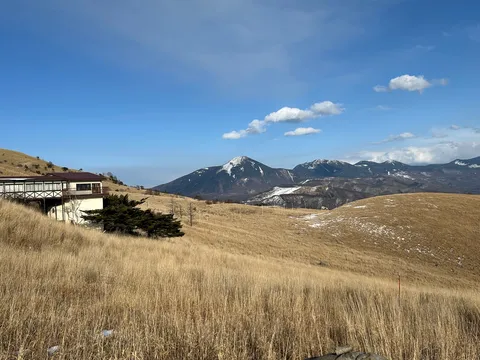 枯れ草と雪化粧の山並み